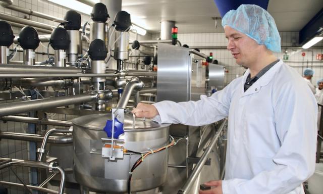 Medewerker van IMD bij een installatie in een zuivelfabriek