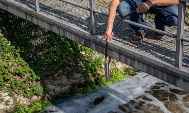 Een sensor wordt in stromend water gehangen